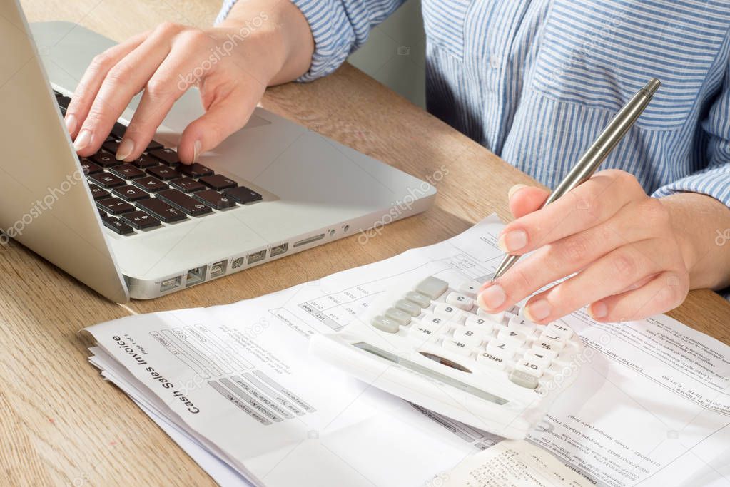 Person in Shirt at Desk Bookkeeping with Laptop and Calculator