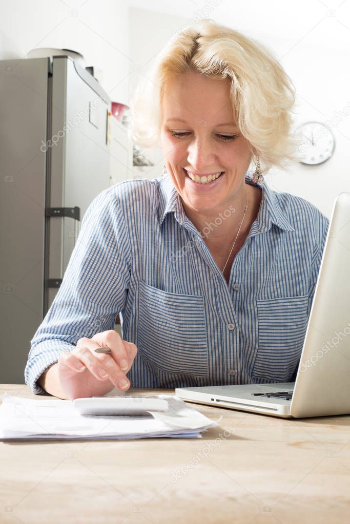 Sitting Woman Looks Happy while Calculating Accounts at Home