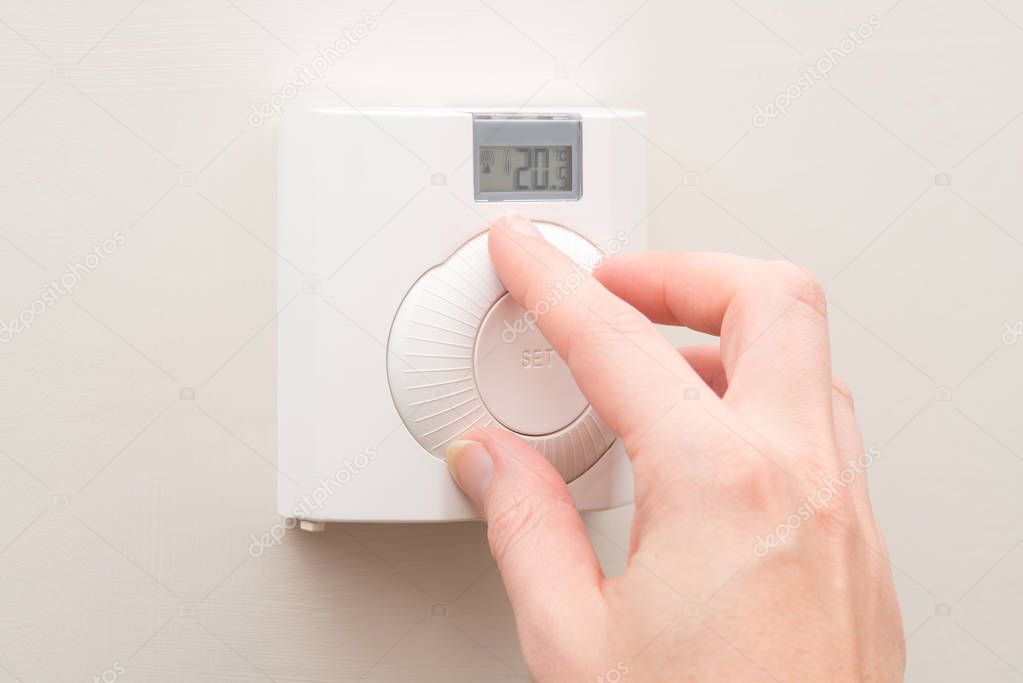 Hand Turning Dial on Wall Mounted Thermostat 