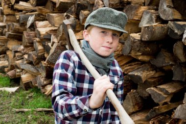 Çocuğun önünde odun yığını
