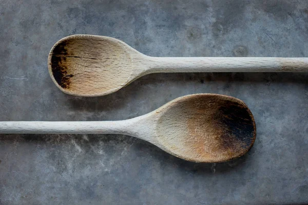 Dos cucharas viejas de madera sobre un fondo gris — Foto de Stock