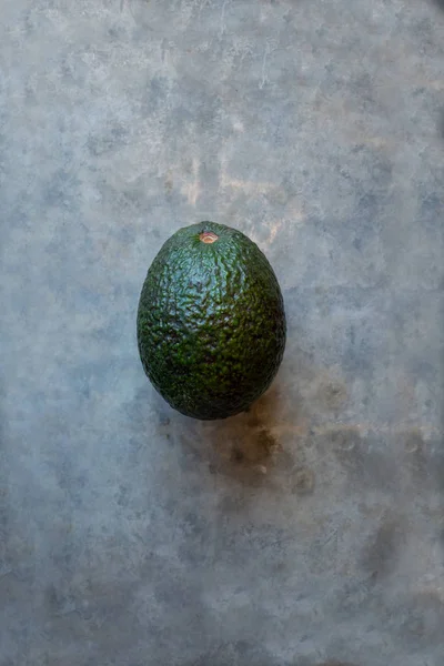 Avocado auf grauer Oberfläche — Stockfoto