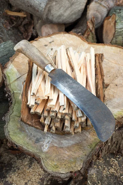 Cuchillo de cacao en un montón de palos de leña — Foto de Stock