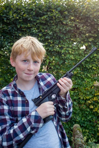 Retrato de niño sosteniendo una pistola de aire —  Fotos de Stock