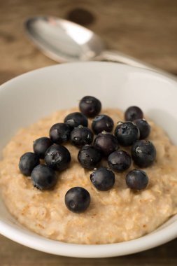 Ahşap adam üzerinde yulaf ezmesi kahvaltı püresi, Blueberry tepesinde