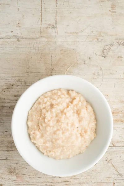 Schüssel Brei auf Holzgrund mit Kopierraum — Stockfoto