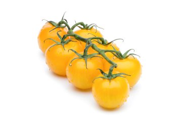 Su damlacıkları ve gölge ile beyaz bir arka plan üzerinde çekilen asma yedi sarı domates