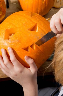 Bir bıçak ile bir jack-o-fener oyma Eller