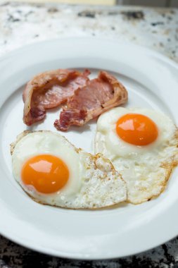 Pişmiş pastırma ve beyaz bir tabakta iki yumurta