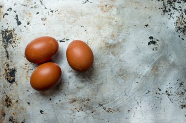 Alüminyum yüzeyde fotokopi alanı ile kahverengi kabukları üç yumurta