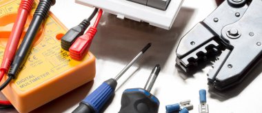 Tel kesiciler, multimetre, tornavidalar, klipsler ve ışık anahtarı gibi elektrikli yüklenici lerin seçimi. Web sitesi afiş biçimi.