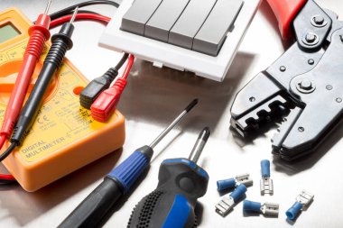 Tel kesiciler, multimetre, tornavidalar, klipsler ve ışık anahtarı gibi elektrikli yüklenici lerin seçimi.