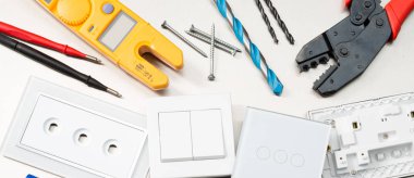 Multimetre, tornavidalar, tel kesiciler, matkap uçları, anahtarlar ve soketler dahil olmak üzere çeşitli elektrikli aletler ve bileşenler. Web banner biçimi.
