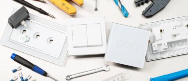 Multimetre, tornavidalar, tel kesiciler, matkap uçları, anahtarlar ve soketler dahil olmak üzere çeşitli elektrikli aletler ve bileşenler. Web banner biçimi.