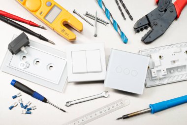 Multimetre, tornavidalar, tel kesiciler, matkap uçları, anahtarlar ve soketler dahil olmak üzere çeşitli elektrikli aletler ve bileşenler.