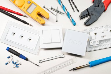 Multimetre, tornavidalar, tel kesiciler, matkap uçları, anahtarlar ve soketler dahil olmak üzere çeşitli elektrikli aletler ve bileşenler.