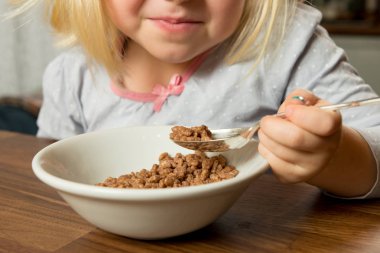 Şekerli kahvaltı gevreği genç bir kız tarafından yeniyor.