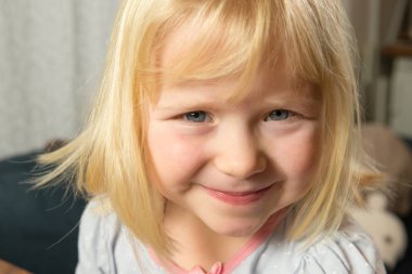 Mutlu gülümseyen beş yaşındaki sarışın kıza yaklaş.