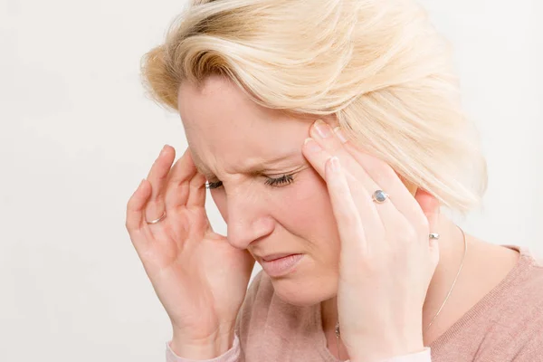 Mujer con dolor tocando los lados de la cabeza — Foto de Stock