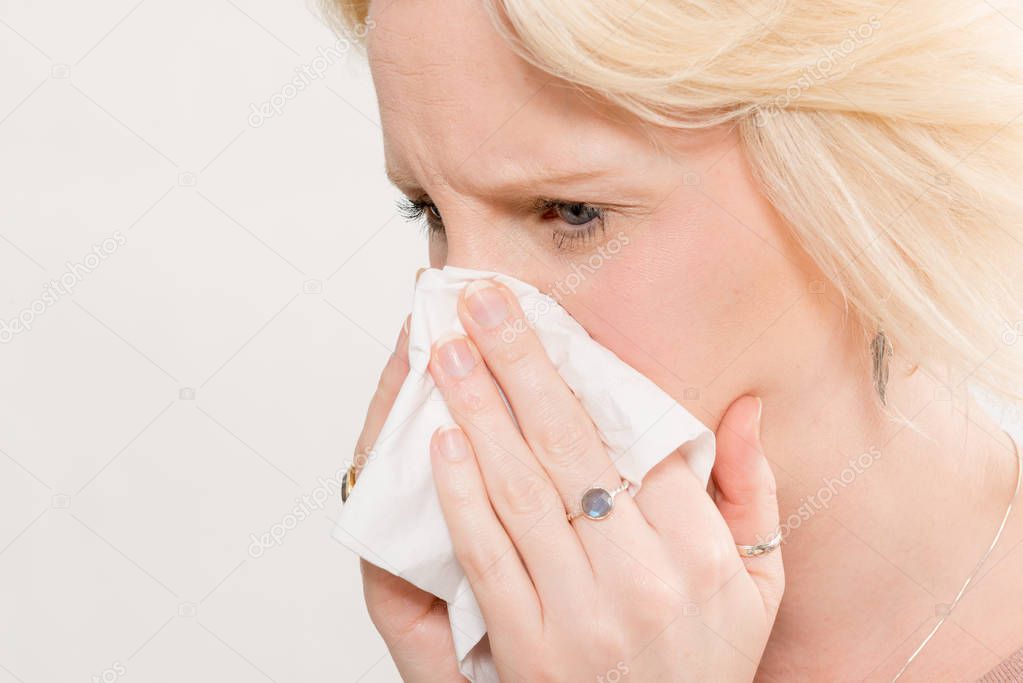 Closeup of Woman Pressing Tissue On Nose with Copy Space