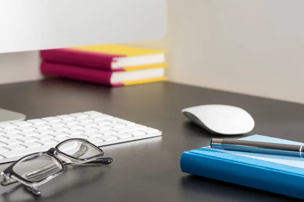 Notebook en Pen brillen naast Computer op kantoor — Stockfoto