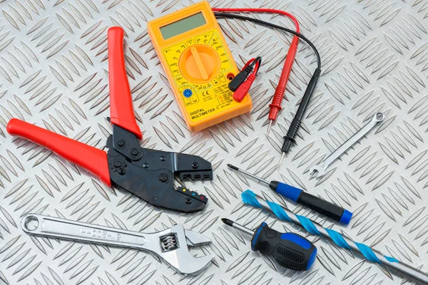 Herramientas y equipo del electricista en la placa del inspector del metal — Foto de Stock