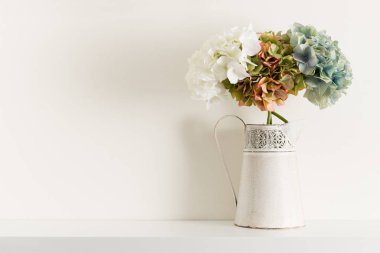 Beyaz raf üzerinde sürahi Vazoda Çiçekler