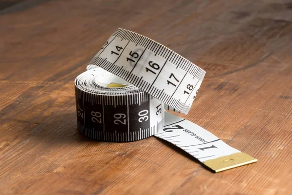 Rolo de fita métrica na mesa de madeira — Fotografia de Stock