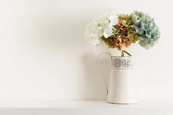 Blumen in Krug-Vase auf weißem Regal — Stockfoto