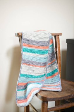 Bir sandalyeye asılı çok renkli Örgü Paspas