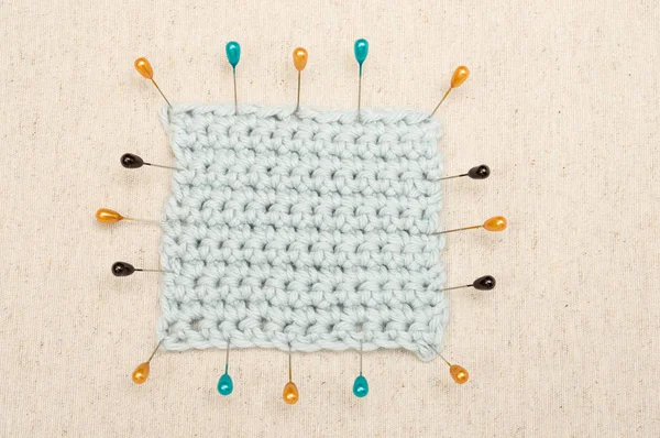淡いブルーのかぎ針編み生地のパッチがピンで固定 — ストック写真