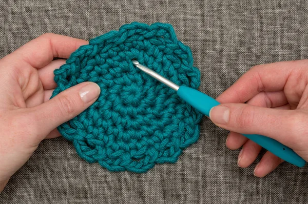 Crochet à tricoter percant un dessous de verre rond en bonneterie sarcelle — Photo