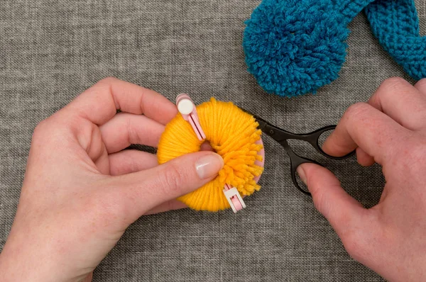 Mãos cortando fio amarelo envolto em torno de Pom-pom Maker — Fotografia de Stock