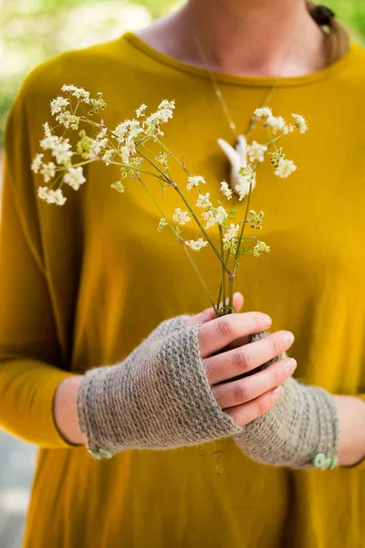 Elinde bir demet çiçek tutan örme Fingerless eldiven