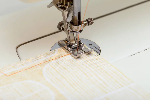 Шитье машины игла сшивание апельсиновой нити на ткани — стоковое фото