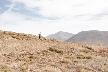 Kadın çölde arka planda dağlar ile çalışır