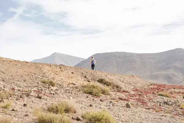 Atletik kadın çöl iz üzerinde bir mesafe koşu
