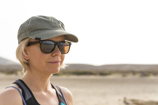Lady indossa occhiali da sole guardando lontano con deserto e colline Backg — Foto Stock