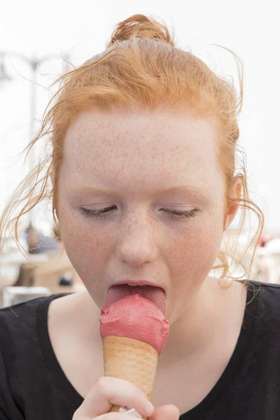 Young Woman Eating Pink Ice Cream on a Cone — Stock Photo, Image