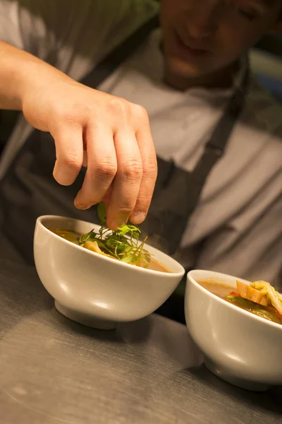 Chef Garnishing tigela de sopa com ervas — Fotografia de Stock