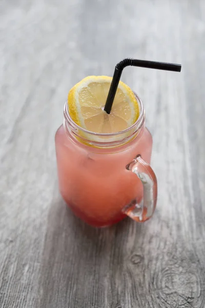 Bebida fresca de pomelo con rodaja de limón y paja para beber — Foto de Stock