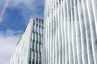 Modern ofis binaları bulutlu mavi gökyüzü üzerinde
