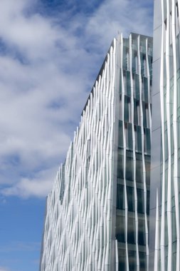 Bulutlu mavi gökyüzü üzerinde modern gökdelen