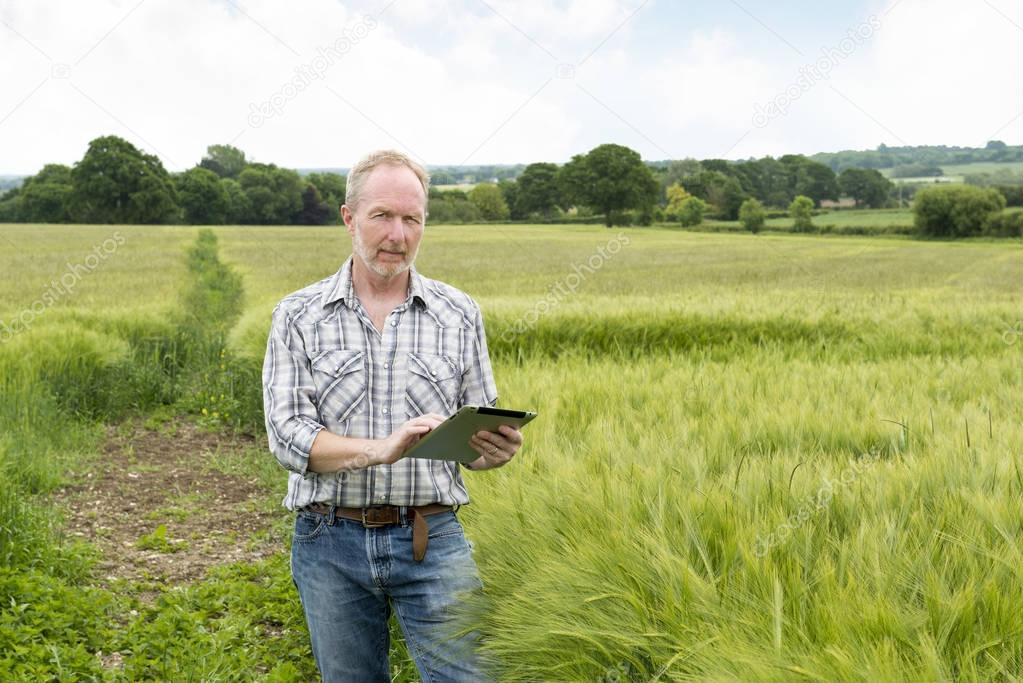 Portrait of Farmer Holding a Tablet Computer in a Field