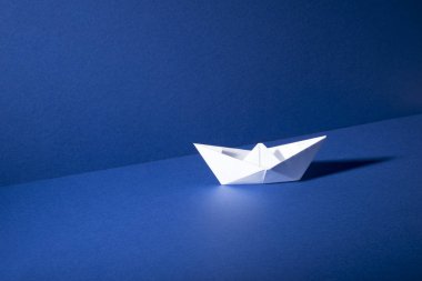 Kağıt tekne mavi zemin ve duvar arka plan üzerinde