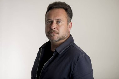 Gri arka plan üzerinde lacivert ceketli adamı