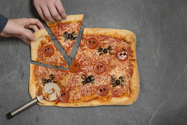 Hands Picking Up Slices of Halloween-Themed Pizza with Pizza Cut — Stock Photo, Image