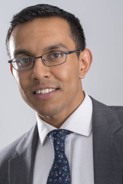 Gözlük, ceket ve kravat gri arka plan üzerinde giyen adam