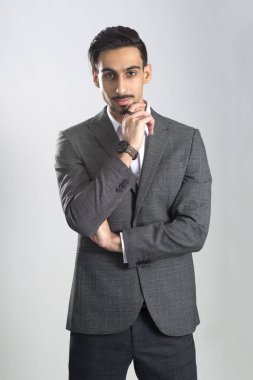 Koyu renk saçlı sakallı genç adam tam gri takım elbise