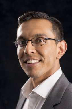 Gözlük ve siyah arka plan üzerinde gri ceket genç adam